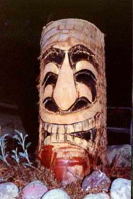 Palm log Tiki 2, a carving by Tiki King